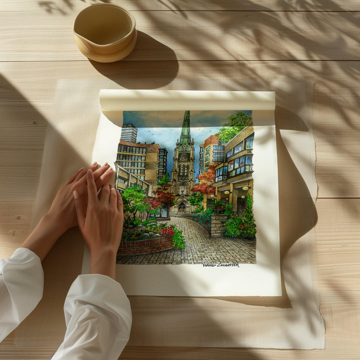 Beautiful illustration of St. James Anglican Cathedral from Toronto Art Shop on a wooden desk, dappled in sunlight. 