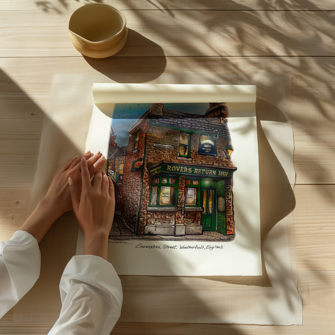 Beautiful illustration of Coronation Street Rover's Return from Toronto Art Shop on a wooden desk, dappled in sunlight.