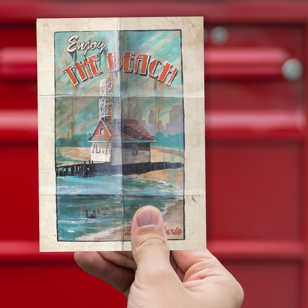 Enjoy the Beach Postcard by Rob Croxford  held up in front of red mailbox