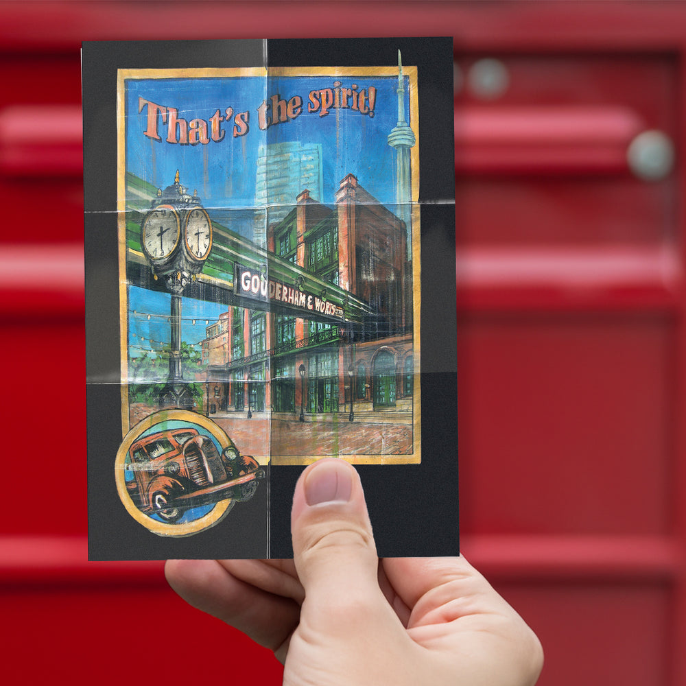 Distillery - That's the Spirit Postcard by Rob Croxford being held up against red mailbox