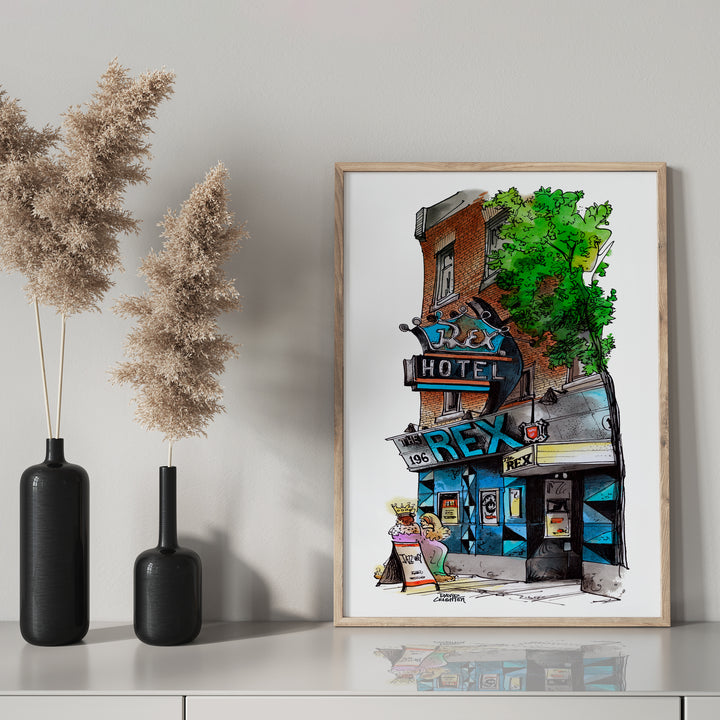 Rex Hotel in a glass frame with black mantel bottle. 