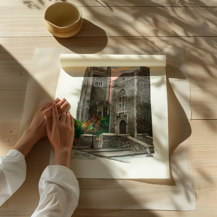 Beautiful illustration of UofT Hart House from Toronto Art Shop on a wooden desk, dappled in sunlight. 