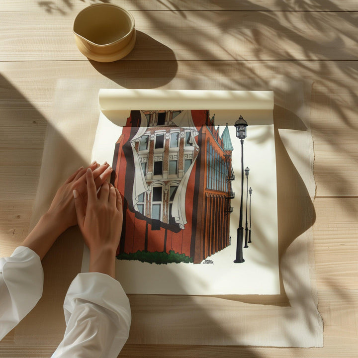 Beautiful illustration of Flatiron Mural from Toronto Art Shop on a wooden desk, dappled in sunlight. 