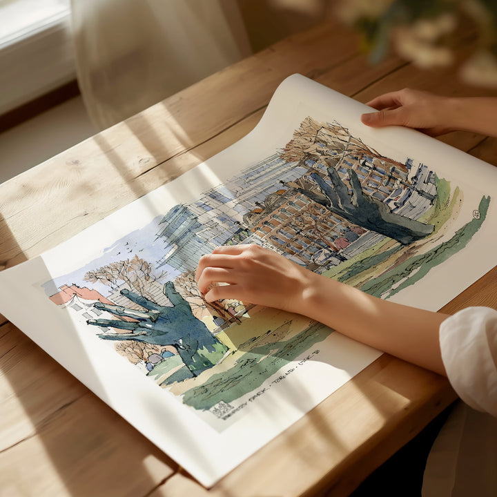 Hands Berczy Park Toronto Poster being unrolled on sunlight dappled desk