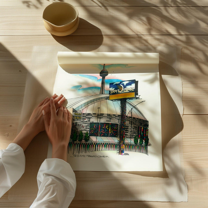 Beautiful illustration of the Toronto Skydome from Toronto Art Shop on a wooden desk, dappled in sunlight. 