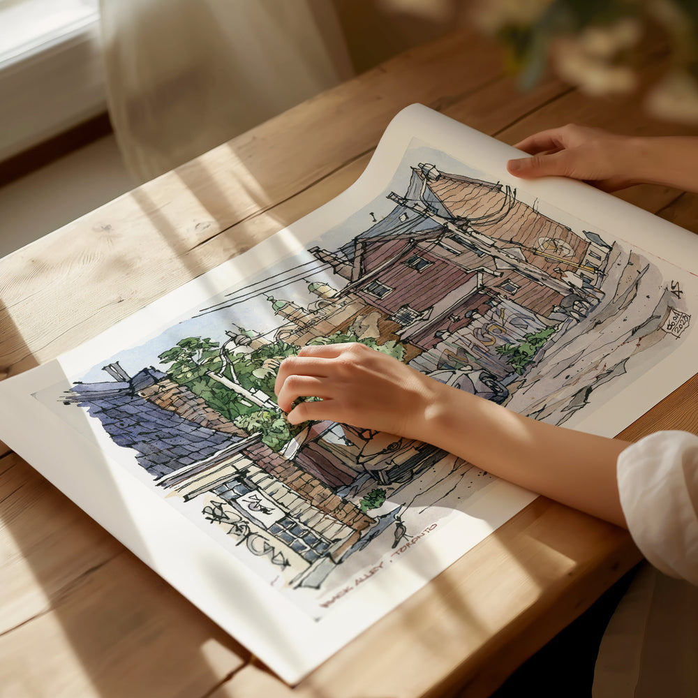 Laneways of Toronto Poster being unrolled on sunlight dappled desk