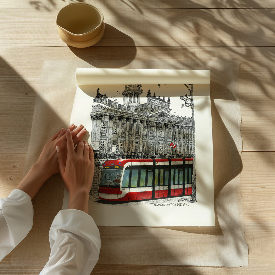 Beautiful illustration of St. Lawrence Hall TTC Black and White from Toronto Art Shop on a wooden desk, dappled in sunlight. 