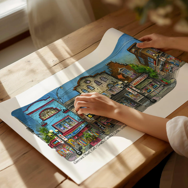 Beautiful illustration of Little India from Toronto Art Shop on a wooden desk, dappled in sunlight. 