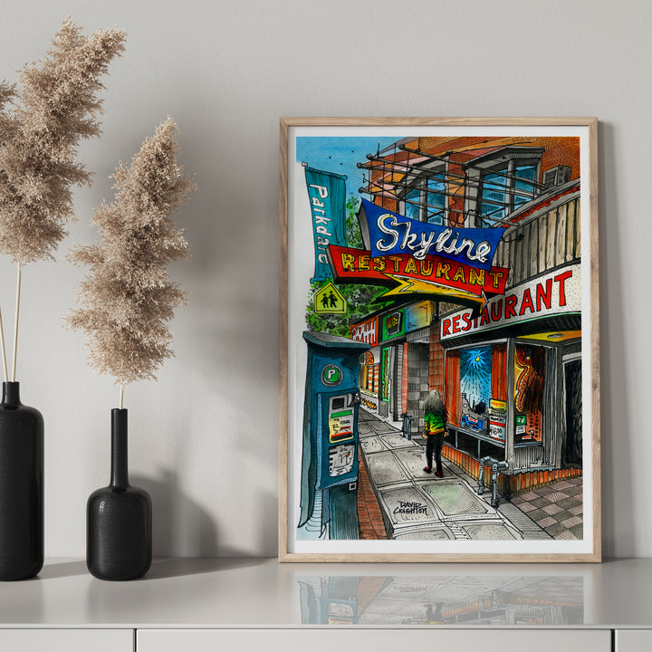 Skyline Restaurant Poster in a glass frame on mantel with black bottle