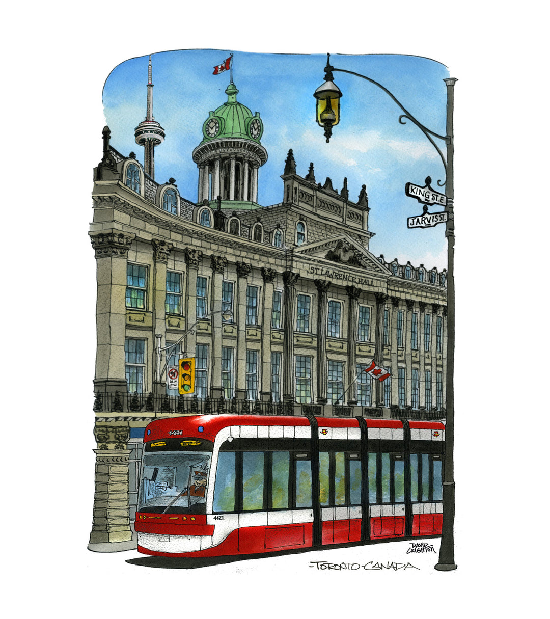 Red and white tram in front of a tall building with a clock tower, street lamp, and traffic lights. Black and White Streetcar 